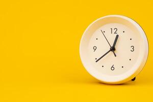 Clock on a yellow background, working with time and planning life, studio photo