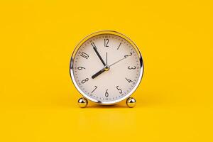 Time and work, the clock stops, the minute hand stops moving, a photo of a clock on a yellow background.