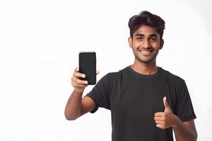 Portrait of happy young indian man using mobile phone and showing thumbs up photo
