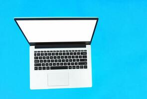 Top view of a business working place with laptop, empty workspace on a bluer table background. Copy space. freelance and telework photo