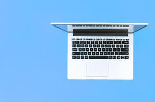 Open laptop on blue background. top view. place for text. online education concept or remote work at home photo