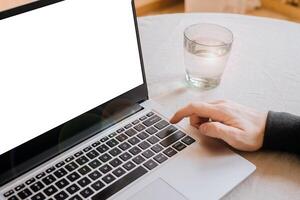 Closeup image of a man finger pressing on the enter button of laptop computer on the table. space for text. telework. freelance photo