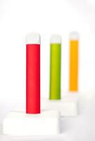 Set of colorful disposable electronic cigarettes on a display stand on a white background. The concept of modern smoking, vaping and nicotine. photo