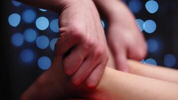 Detail of hands massaging a man's calf muscles. Therapist applying pressure on a woman's leg video