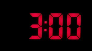 Red digital alarm clock on a black background, in the style of time-lapse . video