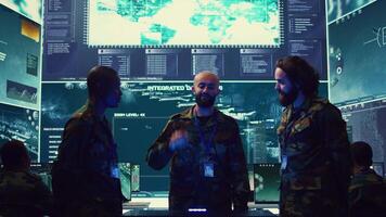 Navy operation specialists monitoring surveillance radar through a hologram, working with 3d illustrations in a military control center. Team of generals gathering intelligence. Camera B. video