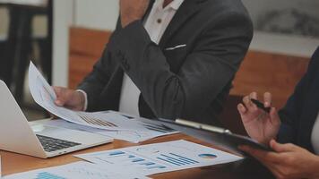 Financial analysts analyze business financial reports on a digital tablet planning investment project during a discussion at a meeting of corporate showing the results of their successful teamwork. video
