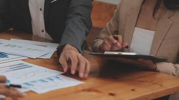 Financial analysts analyze business financial reports on a digital tablet planning investment project during a discussion at a meeting of corporate showing the results of their successful teamwork. video