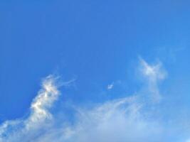 Looking straight up at the the sky. Thin clouds pattern with blue sky as background photo