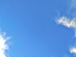 Looking straight up at the the sky. Thin clouds pattern with blue sky as background photo