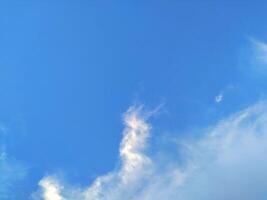 Looking straight up at the the sky. Thin clouds pattern with blue sky as background photo