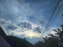 Looking straight up at the the sky. Thin clouds pattern with blue sky as background photo