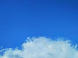 Looking straight up at the the sky. Thin clouds pattern with blue sky as background photo
