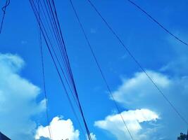 Looking straight up at the the sky. Thin clouds pattern with blue sky as background photo