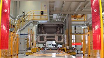 Metal frame of car at factory. Scene. Body frame for truck is assembled at factory. Car and frame assembly at modern factory video