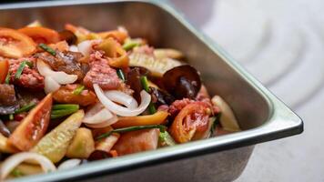 Close-up view of sweet and sour stir fry filled with pork pieces. photo