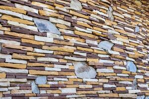 The background is a brick wall with old stone slabs that are placed irregularly. photo