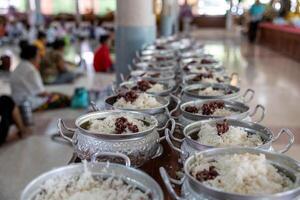 Close-up view of cooked rice packed in various aluminum pots. photo