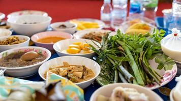 Close-up view of boiled eggs, curry, boiled, stir-fried and many other dishes packed in bowls. photo