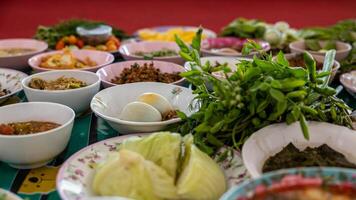 Close-up view of boiled eggs, curry, boiled, stir-fried and many other dishes packed in bowls. photo