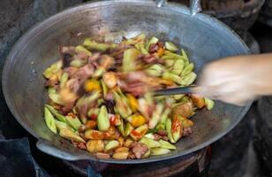 Close-up, blurry motion of a female cook's hand roasting and stir-frying pork. photo