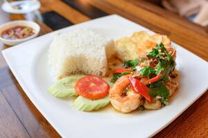 Stir-fried basil, chili with shrimp, squid with fried egg and white rice photo