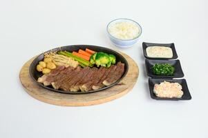 Japanese wagyu beef slices set with vegetables and sauce on pan photo