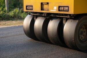Heavy vibration yellow steamroller or soil compactor working on hot-mix asphalt pavement road photo