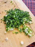 cooking chopped green onion on the wooden board photo