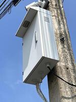 telecommunication junction box on high voltage tower with blue sky and clouds photo