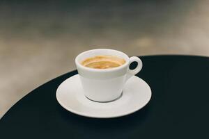Cup of black coffee on a table in a street cafe. photo