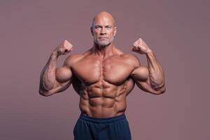 Fit bald man poses showing off his ripped muscles and strength on a neutral background photo