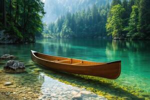 Tranquil canoe rests on the clear waters of a lush, forested lake with misty mountains in the background photo