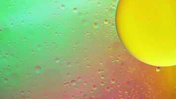 Abstract yellow, green and pink colorful background with oil on water surface. Oil drops in water abstract psychedelic, abstract image. photo