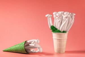shimeji mushrooms with green moss in an ice cream cone, on peach fuzz background photo