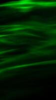 Defocused abstract green background of speed camera movement over glowing lights. A pattern of flashes of light similar to the northern lights photo