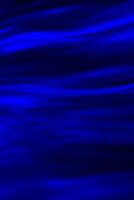 Defocused abstract blue background of speed camera movement over glowing lights. A pattern of flashes of light similar to the northern lights photo