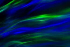 Defocused abstract green and blue background of speed camera movement over glowing lights. A pattern of flashes of light similar to the northern lights photo