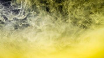 clouds of yellow smoke on a black background, clouds of paint in water, aquarium, abstract background, texture photo