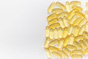 Pile of capsules Omega 3 on white background. Close-up, top view, copy space for your text. photo