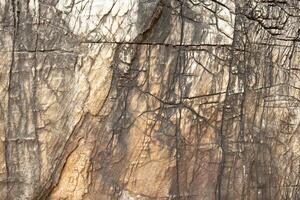 Background image of a cracked textured stone wall that has passed the test of time. photo