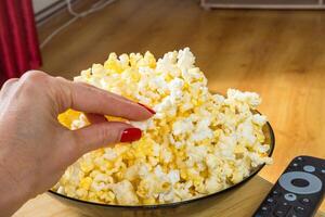 woman Watching smart TV and using remote controller popcorn for watching a movie photo