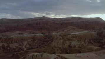 Aerial shot of a desert canyon. ACTION. Gray sky with clouds on rocks. Shooting from above forward in the orange canyon and mountains video