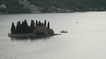 Montenegro, Perast - July 29, 2021. Top view of island with medieval fortress. Creative. Beautiful landscape of island in middle of bay with medieval architecture. St. George Island is historical video