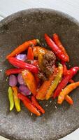 there is a bowl of peppers and other vegetables on a table photo