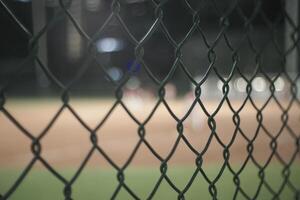 there is a baseball field behind a fence with a baseball field in the background photo