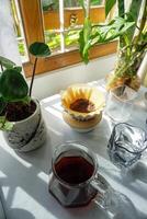 there are three glasses of coffee and a server coffee with origami dripper on a table photo