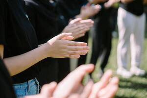 Hands poised to clap, capturing the energy and unity of a team-building event in action photo