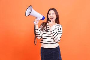 indonesia woman cheerful shouting expression using candid mic standing holding megaphone loudspeaker to make an announcement. for fashion, business and broadcast concepts photo