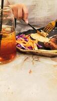 portrait of woman's hands enjoying dajaj mashwi, oven roasted chicken with tearing khubus pita bread with fork and knife on plate photo